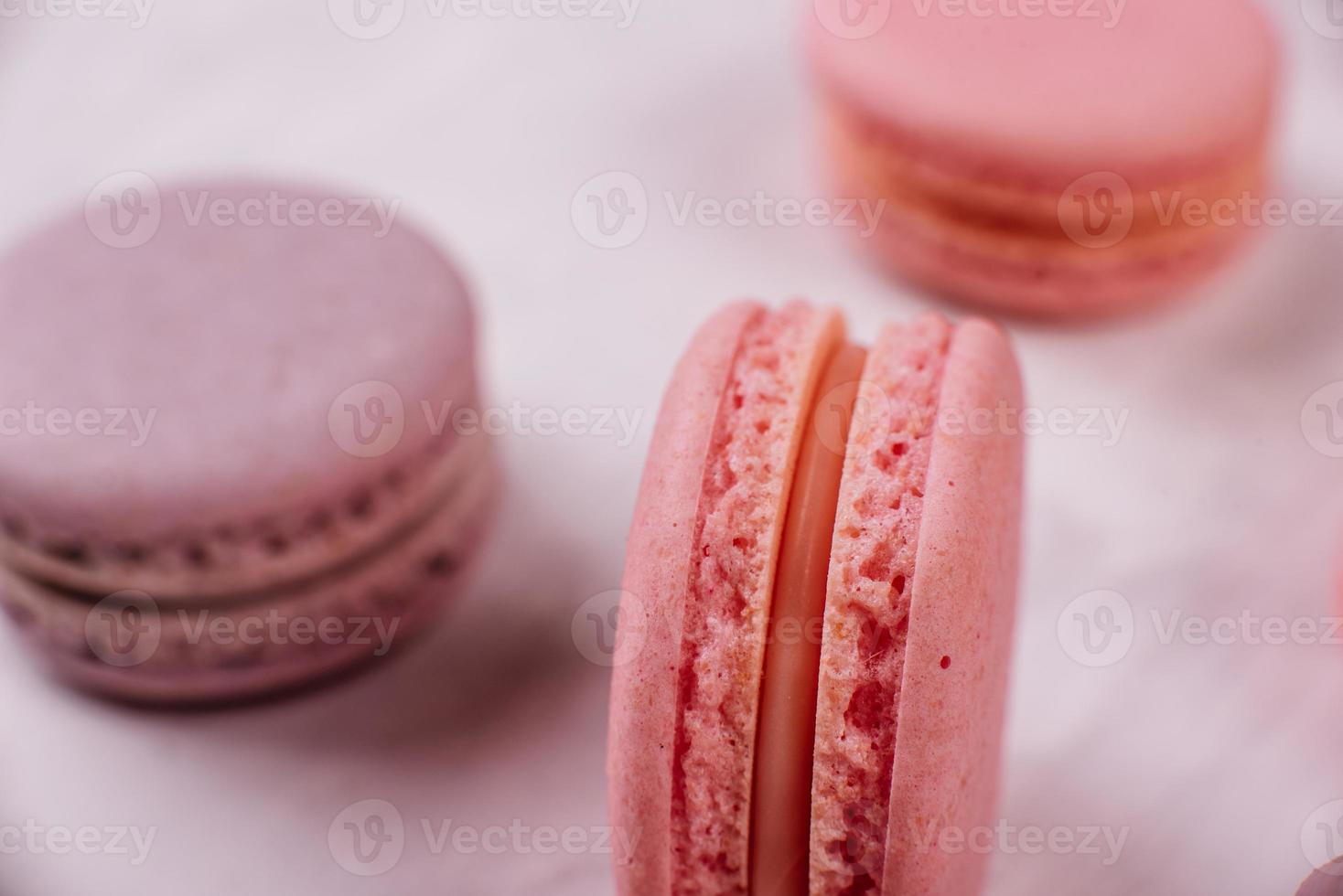 Hermosos macarrones rosados sabrosos sobre un fondo de hormigón foto