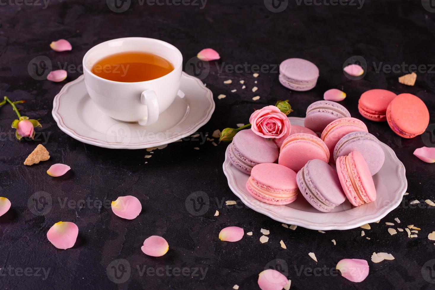 Hermosos macarrones rosados sabrosos sobre un fondo de hormigón foto