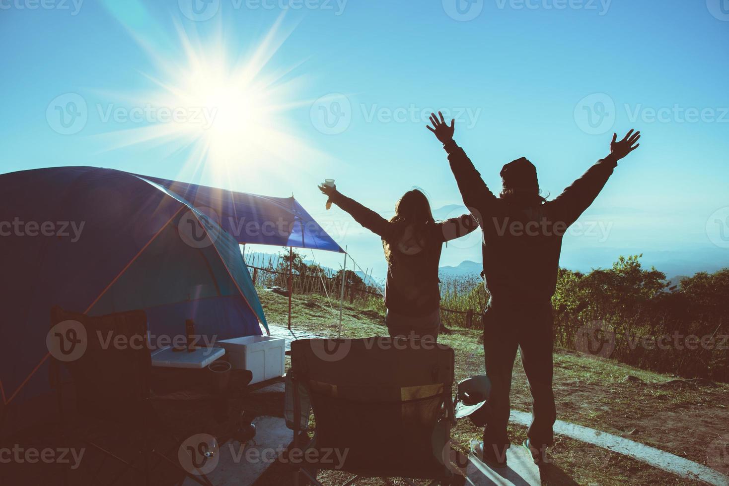 amantes mujeres y hombres asiáticos viajar relajarse acampar en las vacaciones. en la montaña. estar de pie, ver salir el sol. tailandia foto