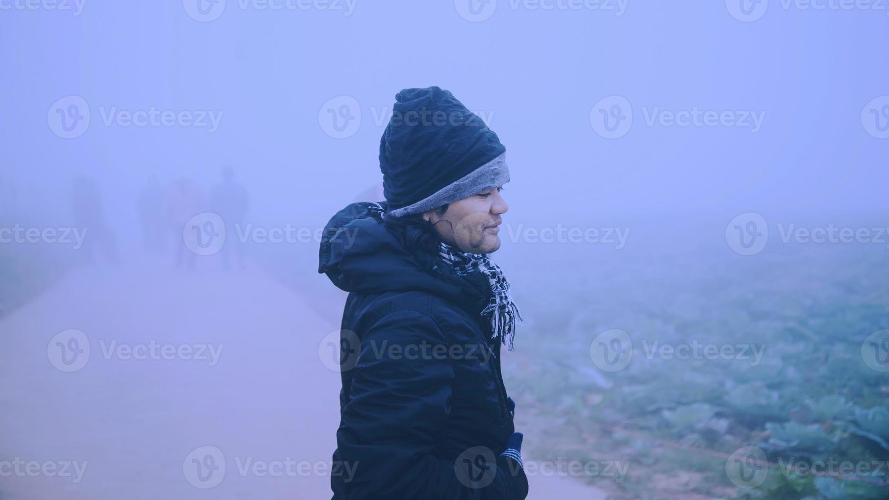 hombre asiático relajarse en las vacaciones. feliz de viajar en las vacaciones. durante el invierno brumoso foto