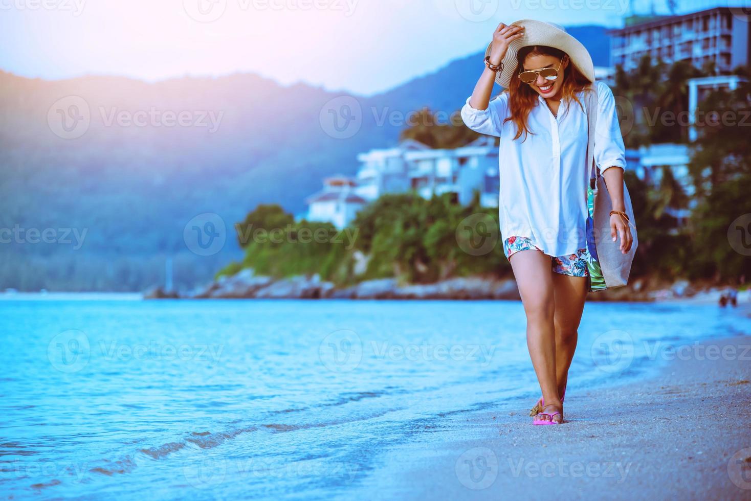 naturaleza de viaje de mujer asiática. viajar relajarse. caminando en la playa. en el verano foto
