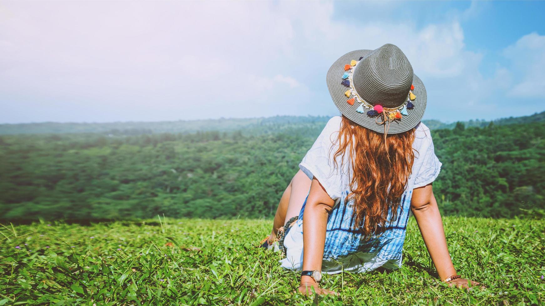 Asian women travel relax in the holiday. seats relax on the lawn on the mountain. In Thailand photo