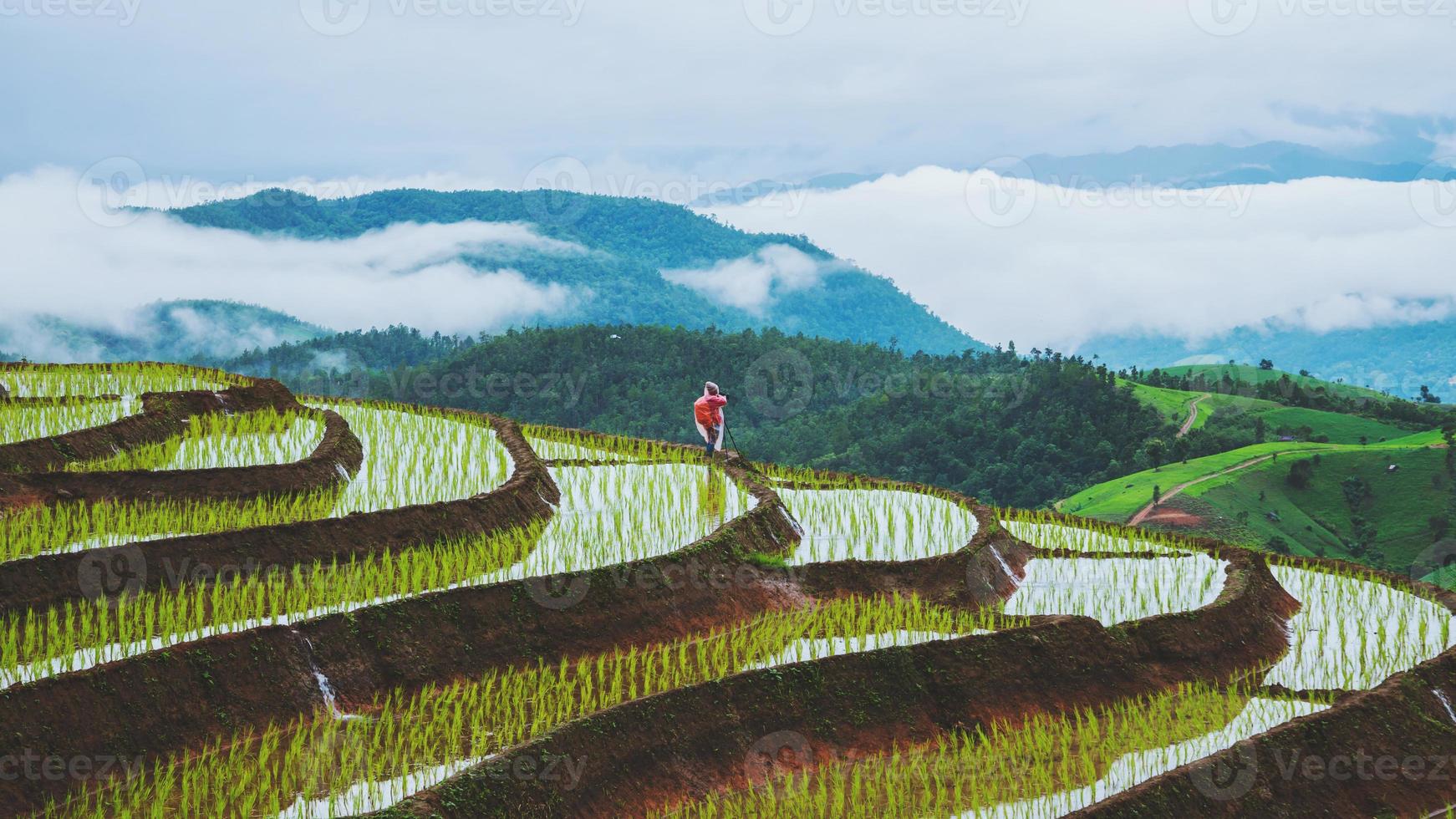 Asian woman travel nature. Travel relax. Walking take a photo on the field. in summer.