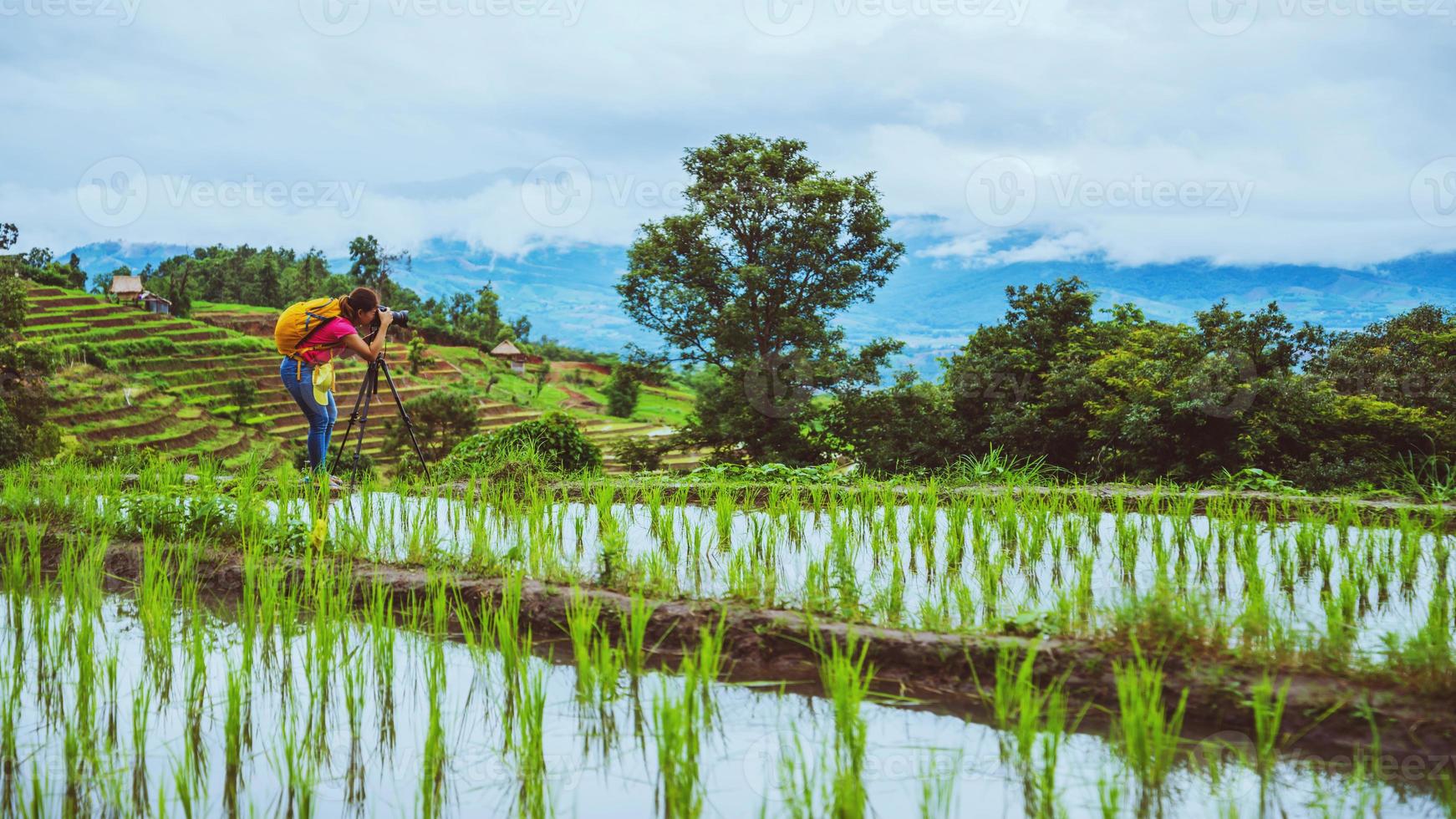 Asian woman travel nature. Travel relax. Walking take a photo on the field. in summer.