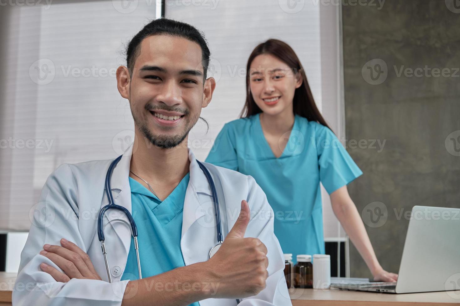 Healthcare partners team, portrait of two young doctors of Asian ethnicity in uniform with stethoscope, smiling and looking at camera in clinic, persons who expertise in professional treatment. photo