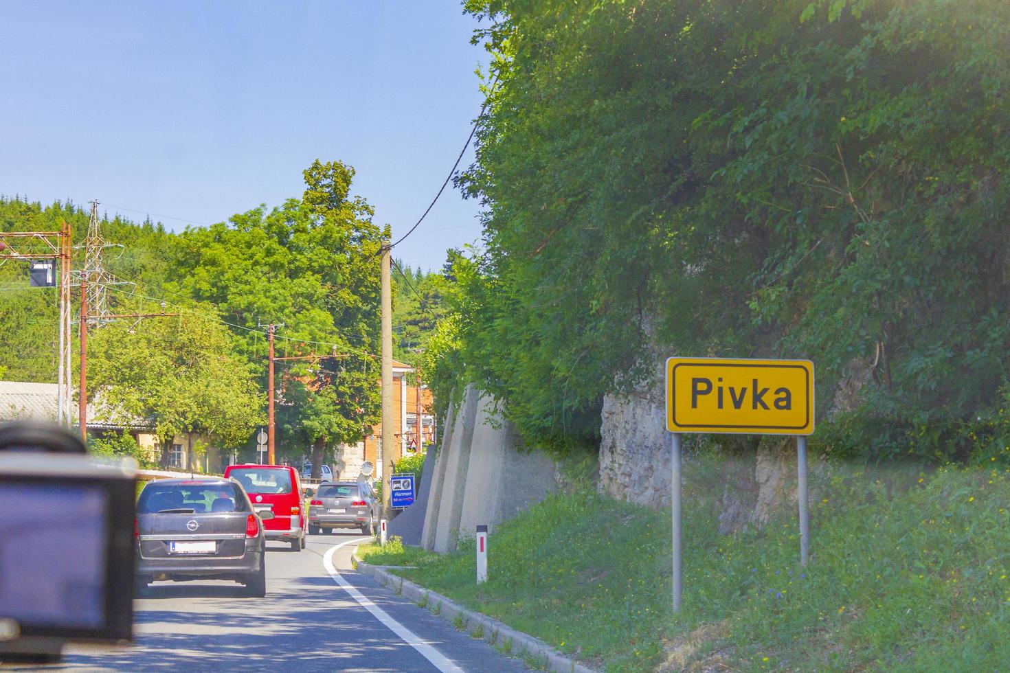 Yellow place-name sign and road to Postojna Pivka Slovenia. photo