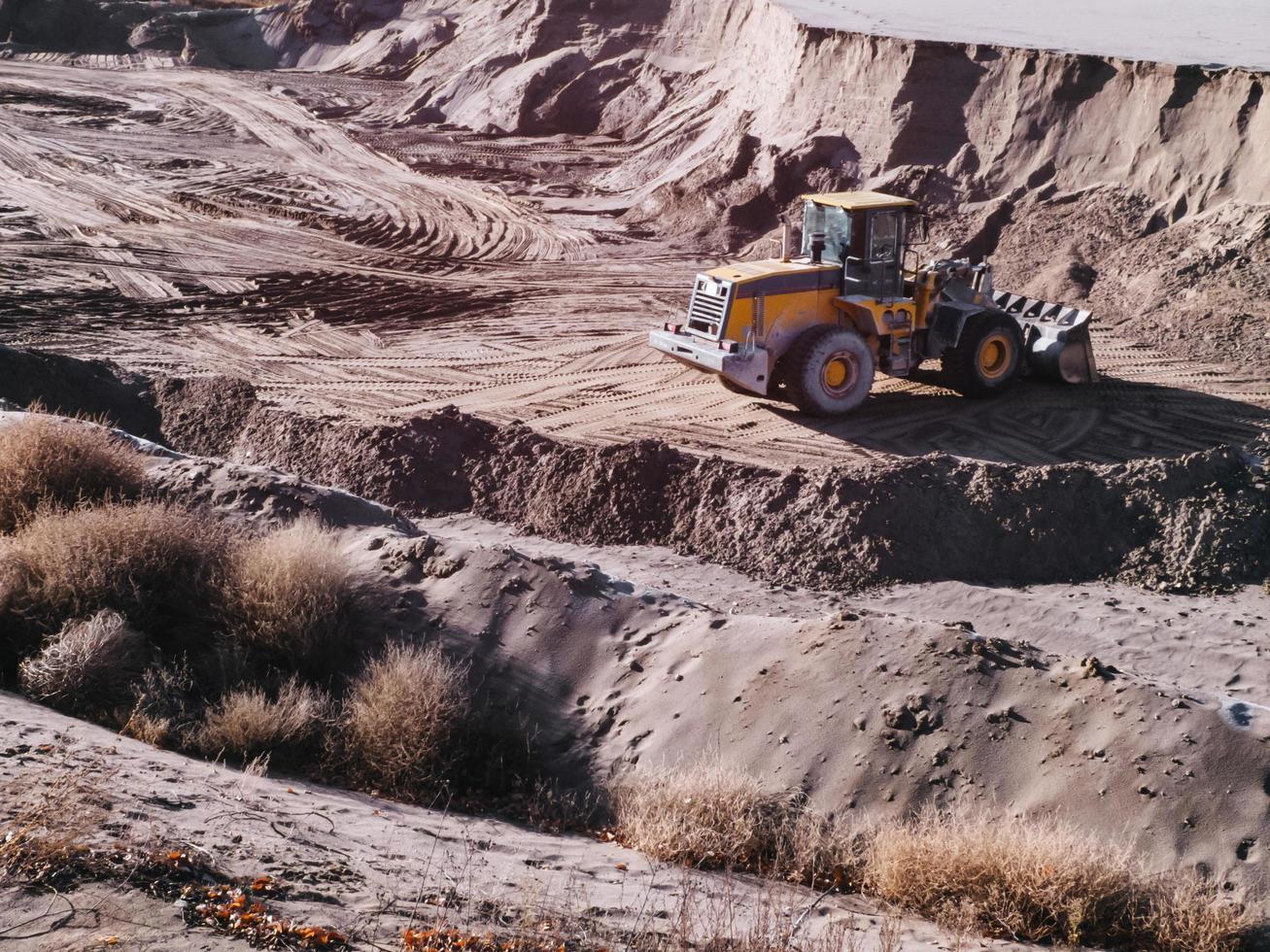 cargador de tractor en el trabajo en un pozo de arena. foto