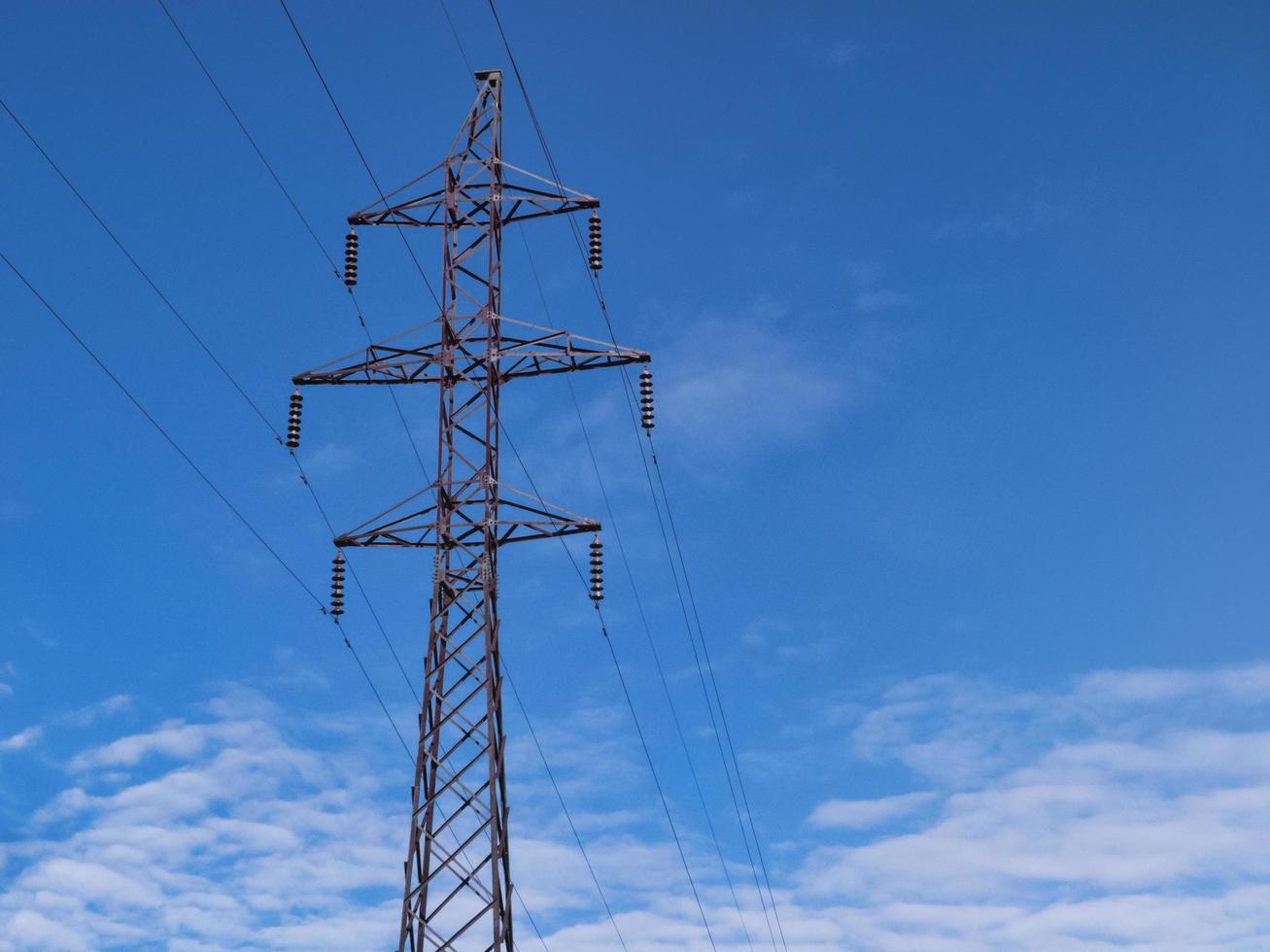 Torre eléctrica de alta tensión sobre fondo de cielo nublado. foto