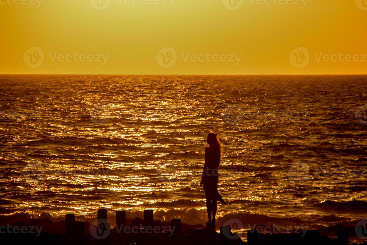 woman watching the sunset in agaete port photo