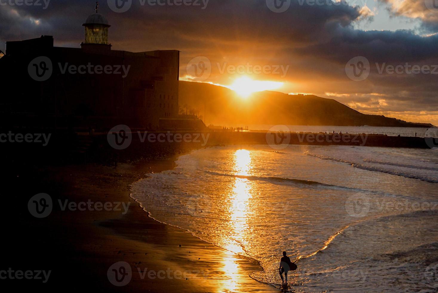 surfing on the beach at sunset photo