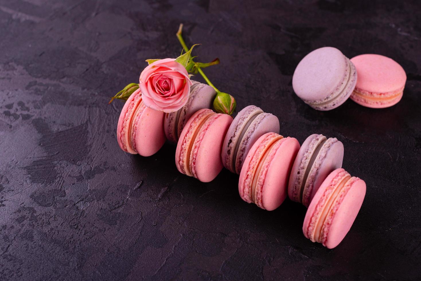 Hermosos macarrones rosados sabrosos sobre un fondo de hormigón foto