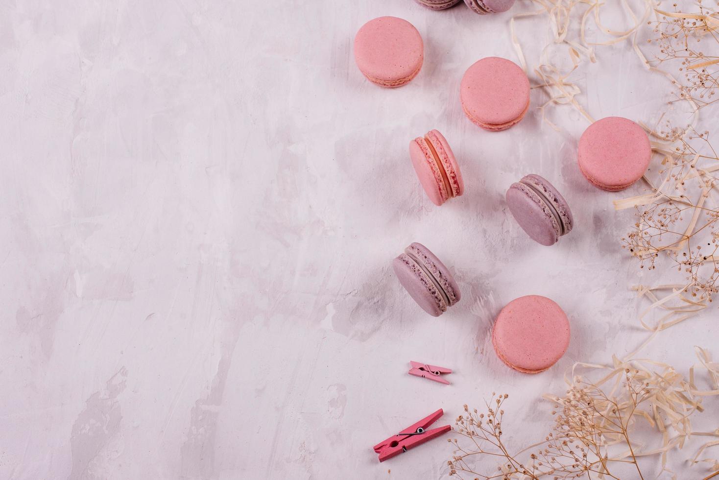 Hermosos macarrones rosados sabrosos sobre un fondo de hormigón foto