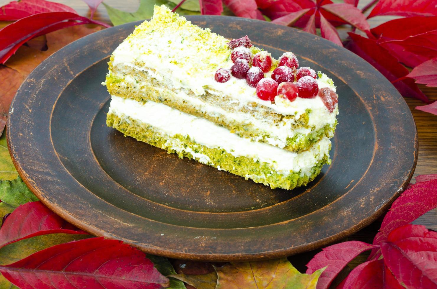 Piece of sponge cake with cream and berries on plate. Studio Photo