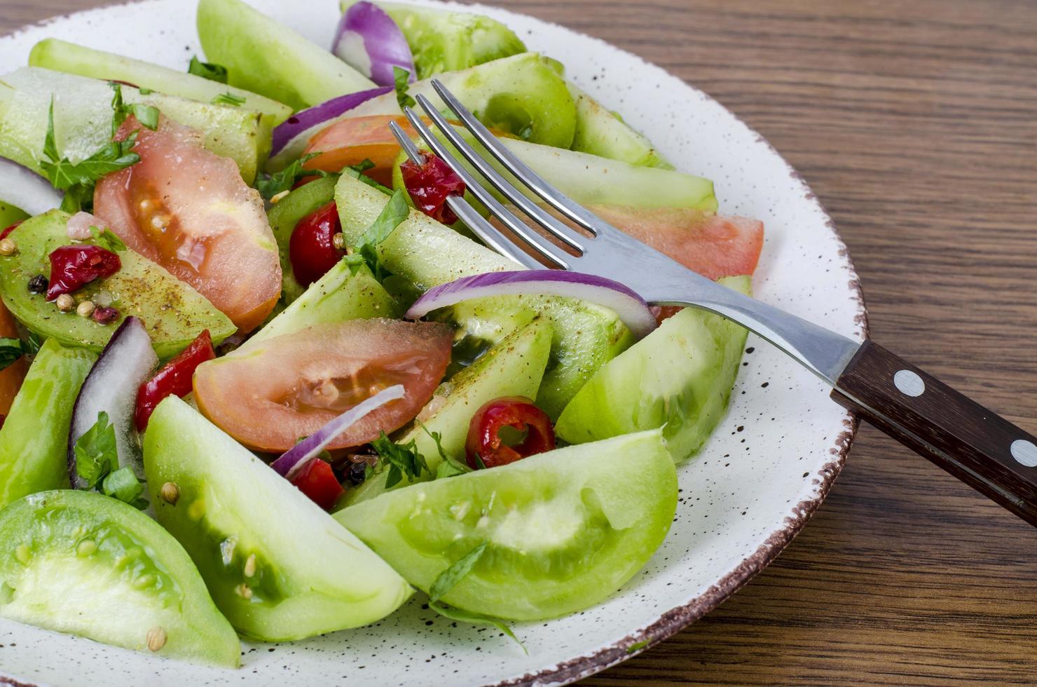 Spicy appetizer of canned pickled red and green tomatoes photo