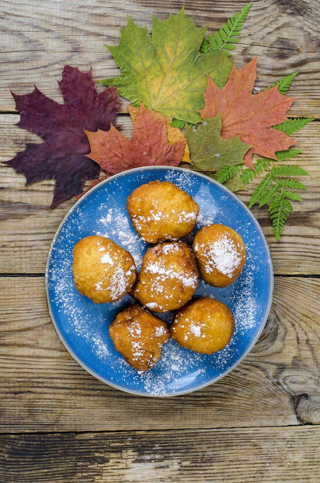 Sweet curd donuts buns with powdered sugar on wooden table photo