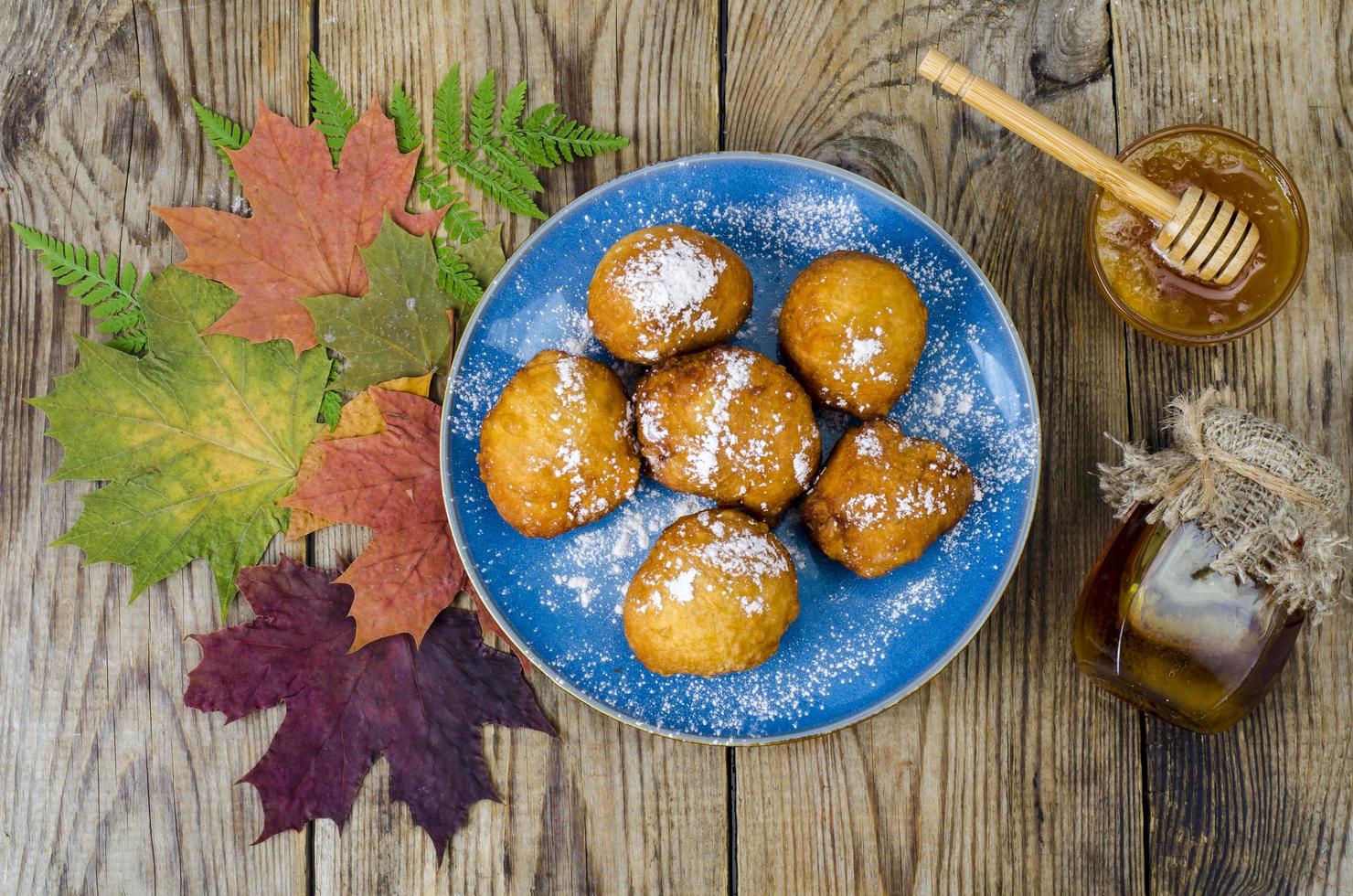 Sweet curd donuts buns with powdered sugar on wooden table photo