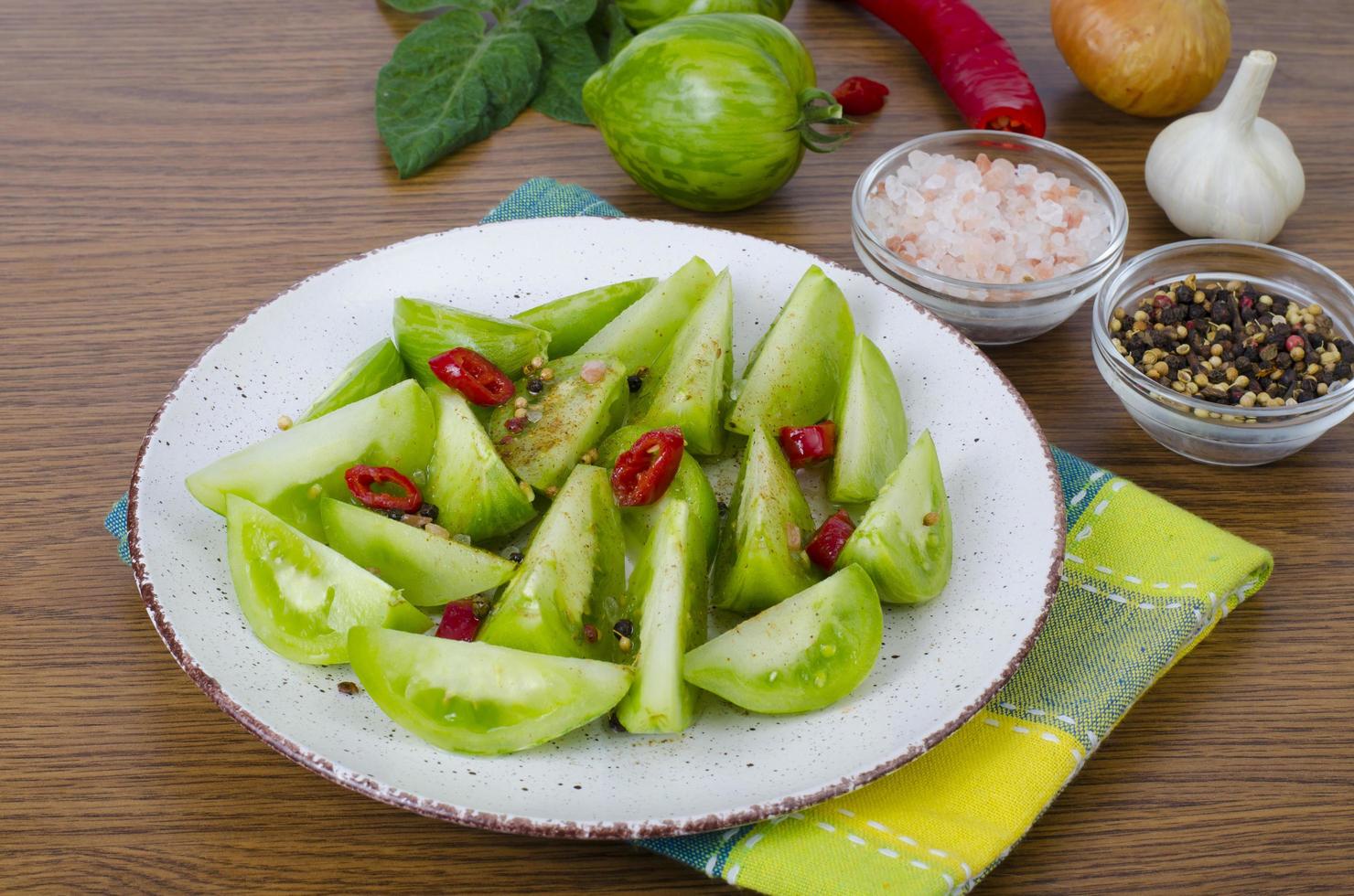 Appetizer of spicy pickled green tomatoes photo