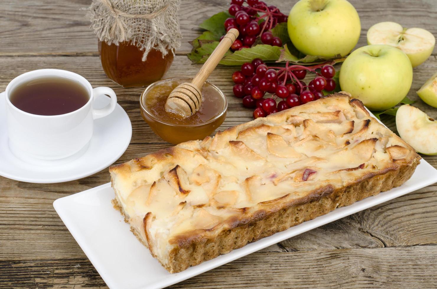 Tarta de manzana de otoño con bayas viburnum sobre fondo de madera foto