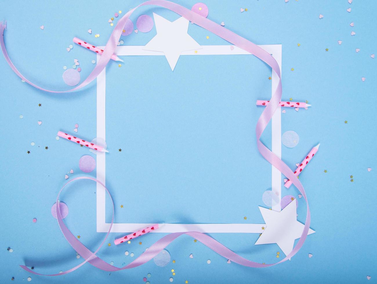 Party Holiday Background with ribbon, stars, birthday candles, gift box empty frame and confetti on blue background photo