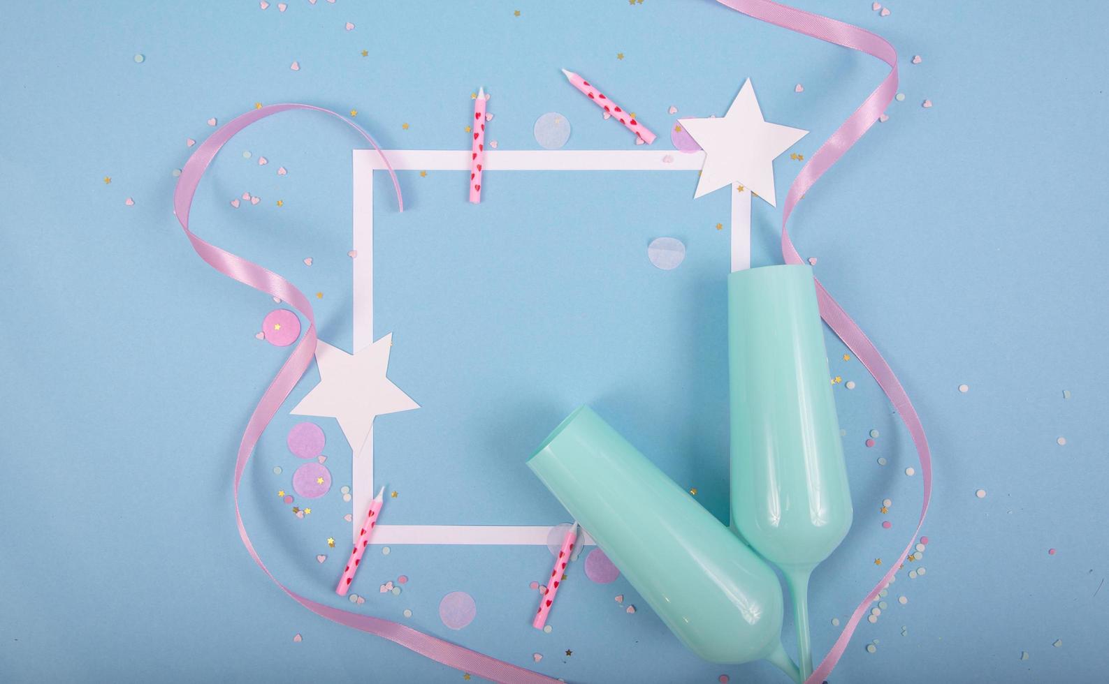 Party Holiday Background with ribbon, stars, birthday candles, empty frame and confetti on blue background photo