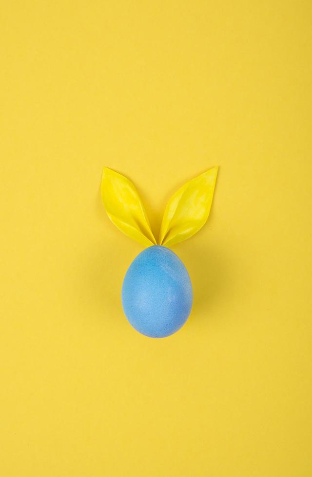Egg with paper ears in the shape of an Easter bunny. Happy Easter Concept Card Postaer Background photo