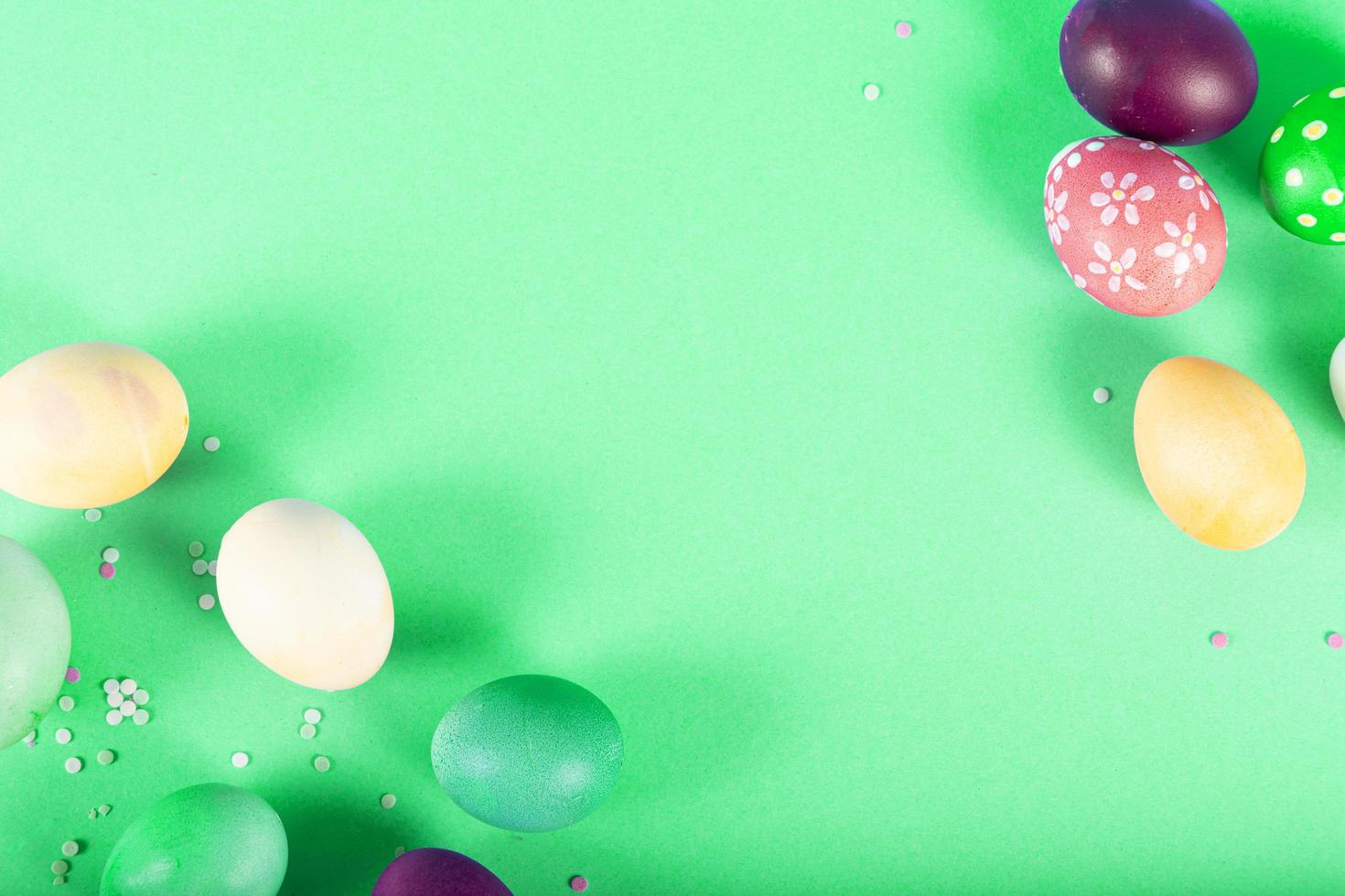 Fondo de colores con huevos de Pascua sobre fondo verde. concepto de feliz pascua. se puede utilizar como cartel, fondo, tarjeta navideña. endecha plana, vista superior, espacio de copia. foto de estudio