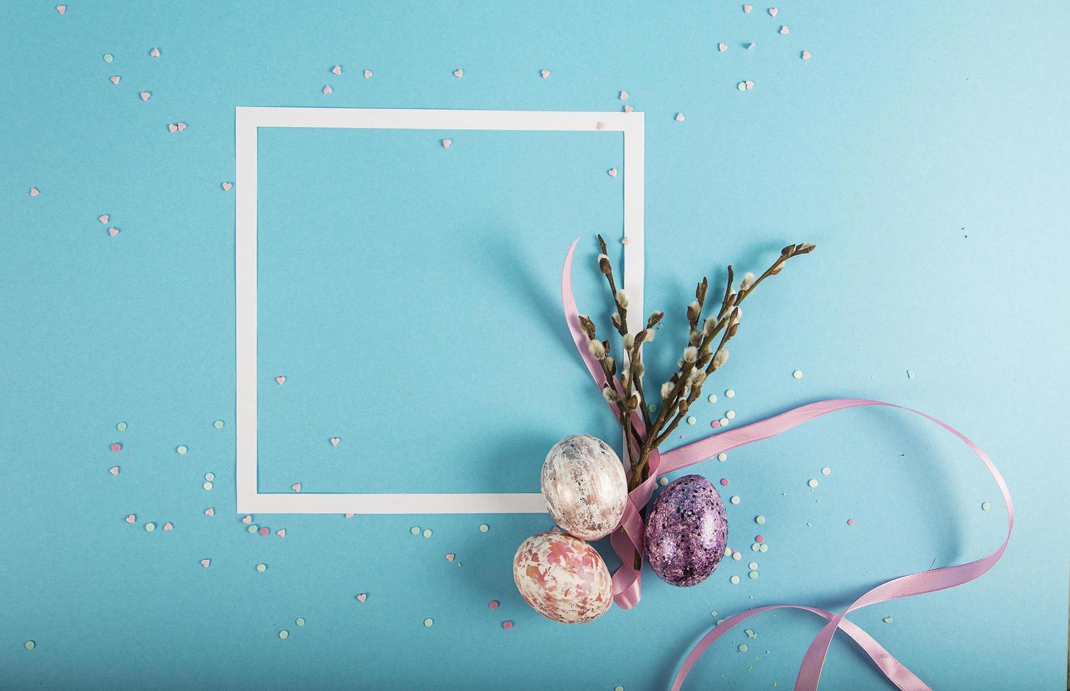 Colorful background with frame, Easter eggs on blue background. Happy Easter concept. Can be used as poster, background, holiday card. Flat lay, top view, copy space. photo