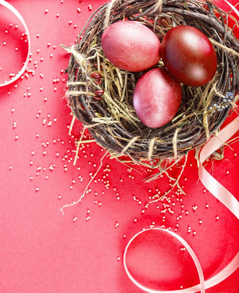 Colorful background with Easter eggs on red- background. Happy Easter concept. Can be used as poster, background, holiday card. Flat lay, top view, copy space. Studio Photo