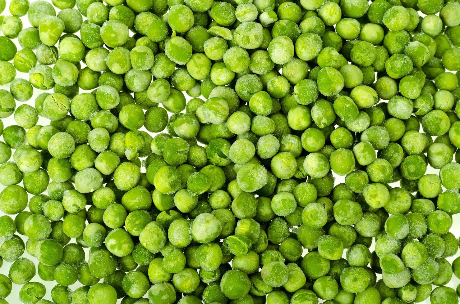 Pile of frozen blanched green peas isolated on white background. Healthy food. Studio Photo