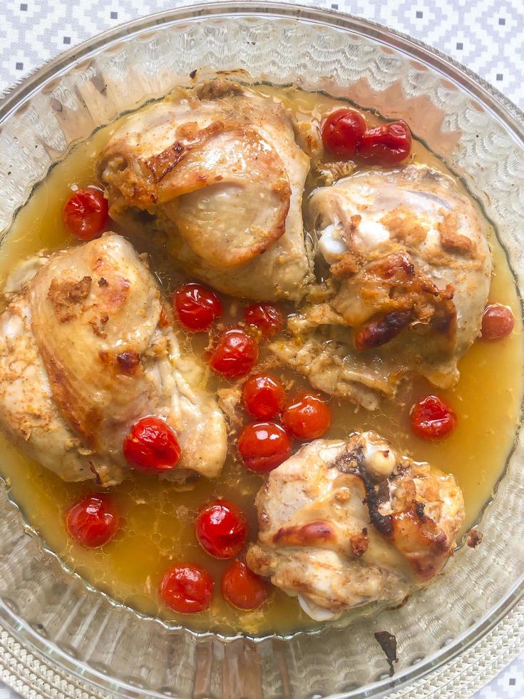 Poultry dishes. Chicken pieces with cherry tomatoes photo