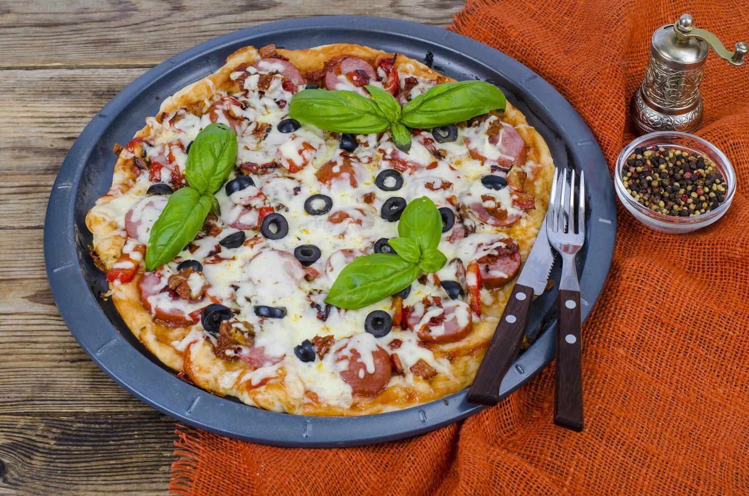 Homemade pizza with salami, mozzarella and olives photo