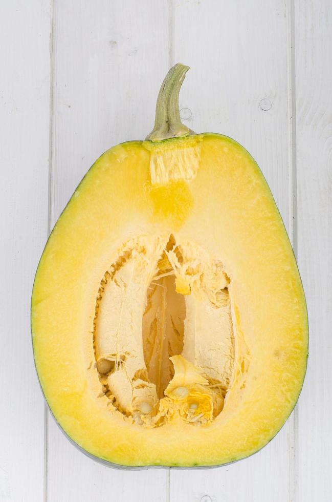 Half ripe butternut squash on wooden surface photo