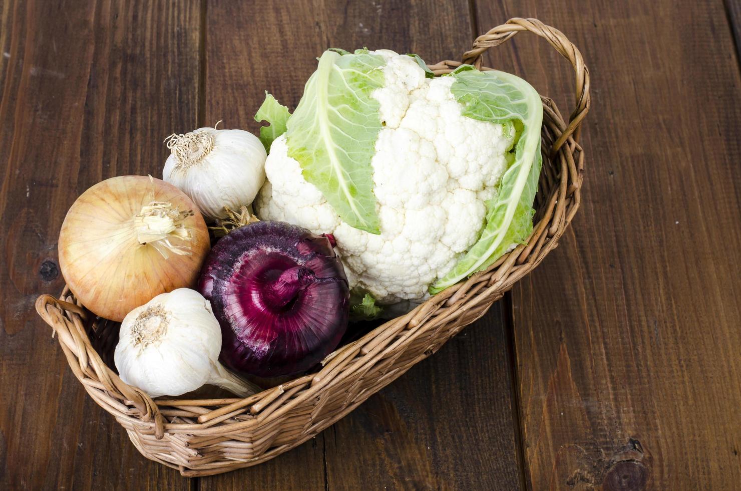 Basket with organic vegetables, cauliflower, onion, garlic. Farm products photo