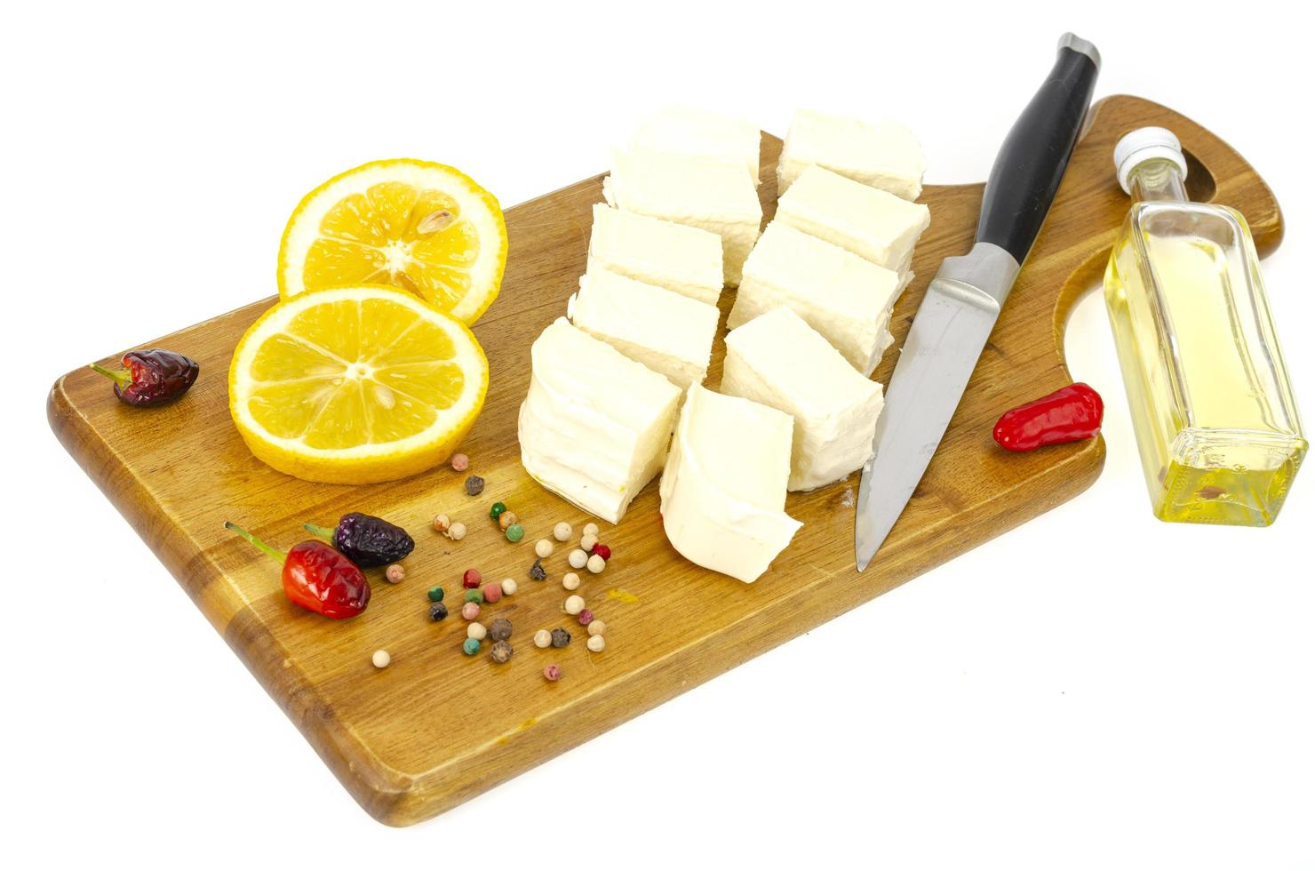 Slices of white fresh feta on wooden cutting board photo