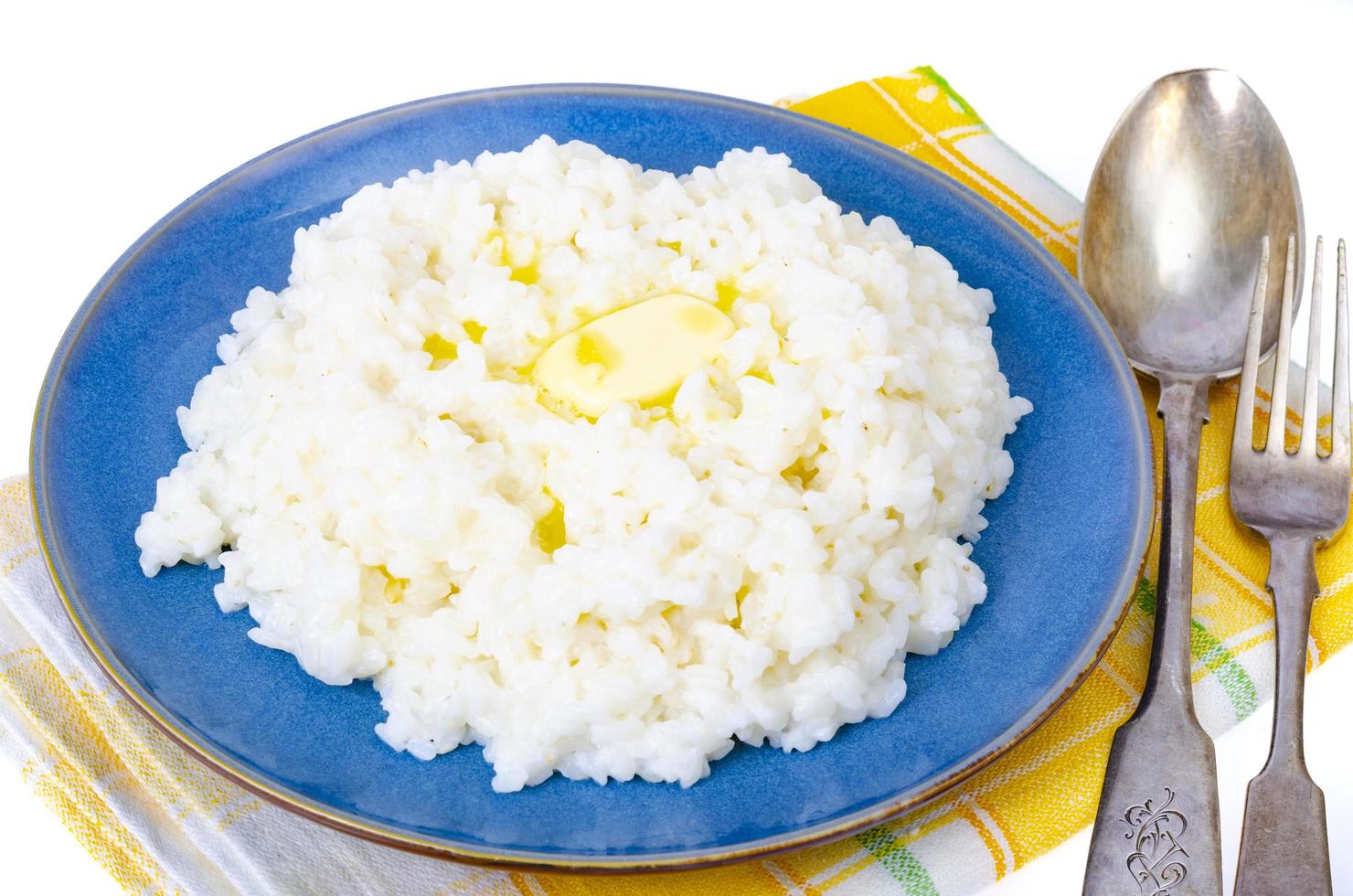 Deliciosas gachas de arroz con leche en placa azul sobre fondo blanco. foto