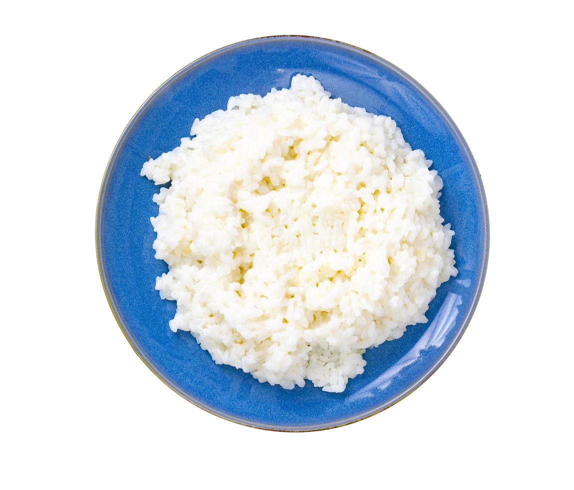 Deliciosas gachas de arroz con leche en placa azul sobre fondo blanco. foto
