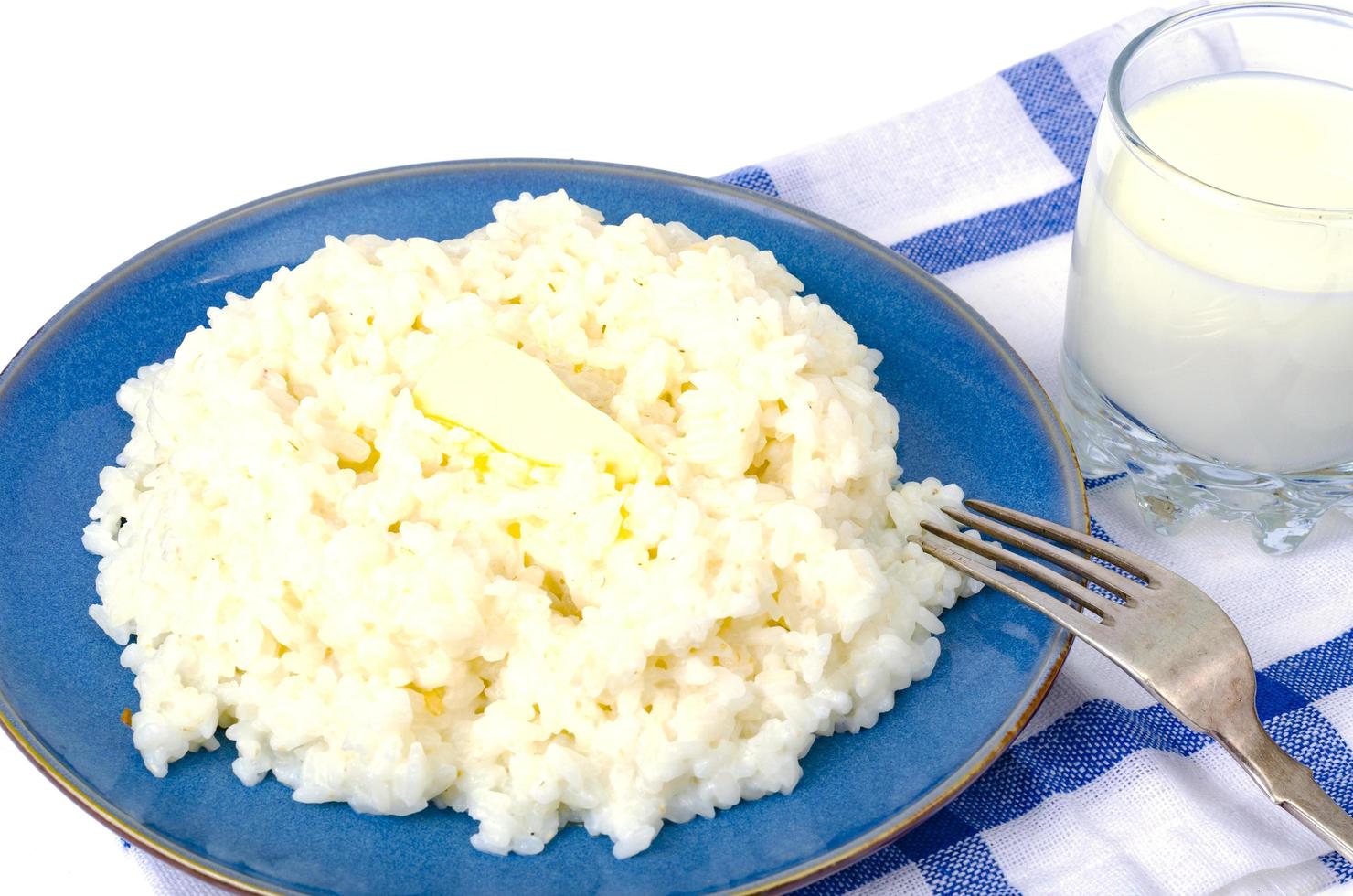 Delicious rice milk porridge in blue plate on white background photo