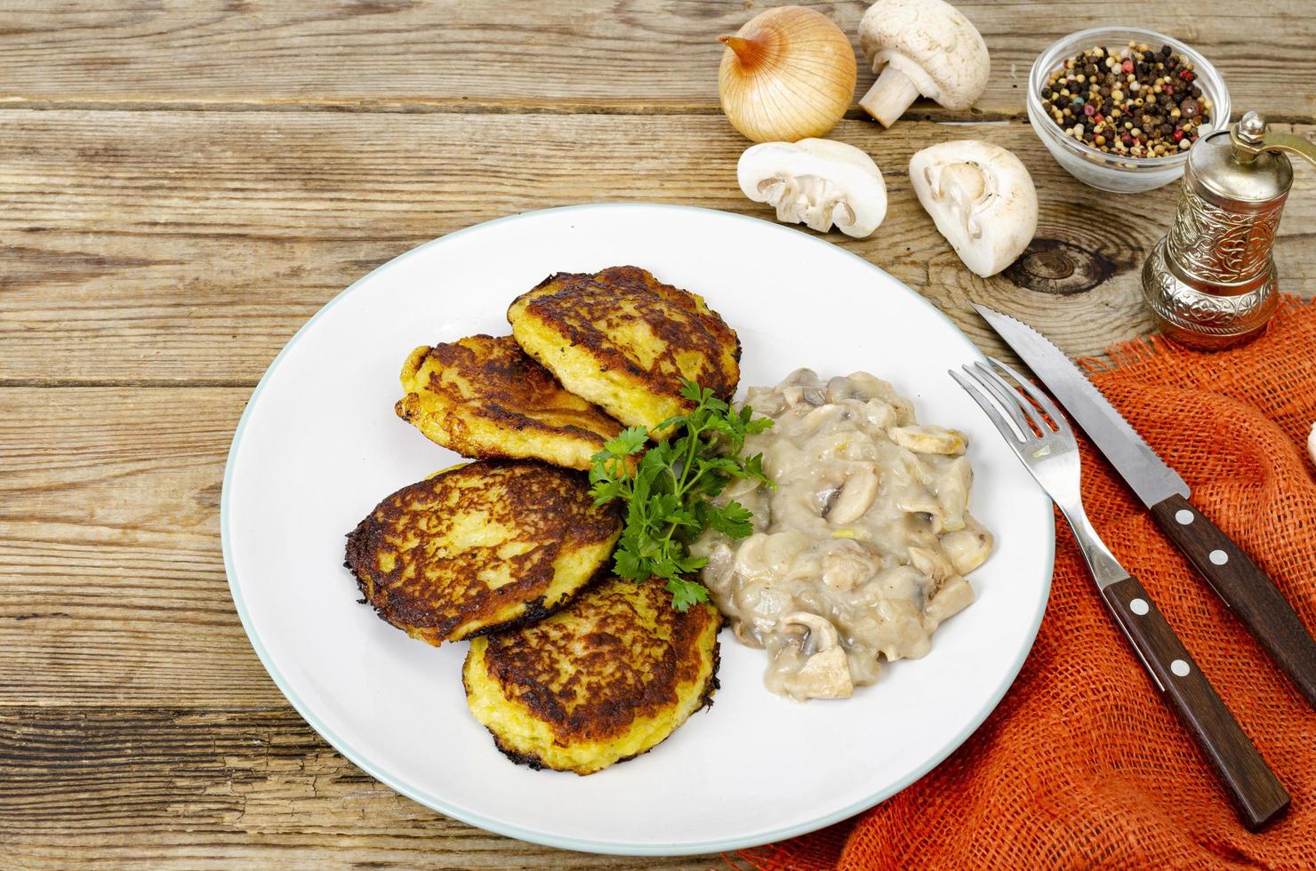 tortitas de patata ralladas fritas con salsa de champiñones. foto de estudio