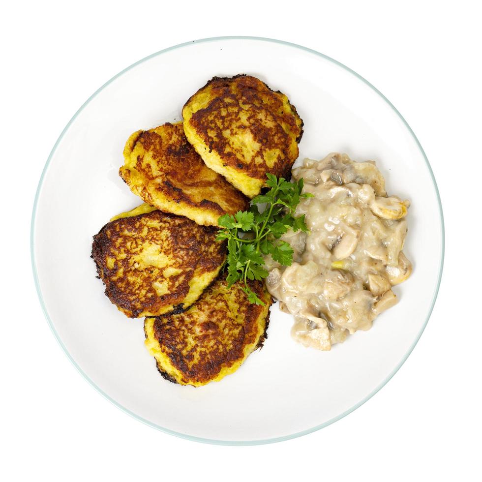 Fried grated potato pancakes with mushroom sauce. Studio Photo