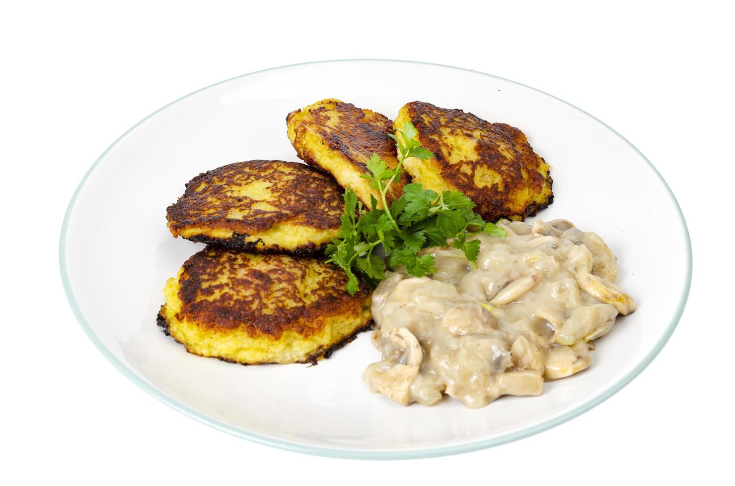 Fried grated potato pancakes with mushroom sauce. Studio Photo