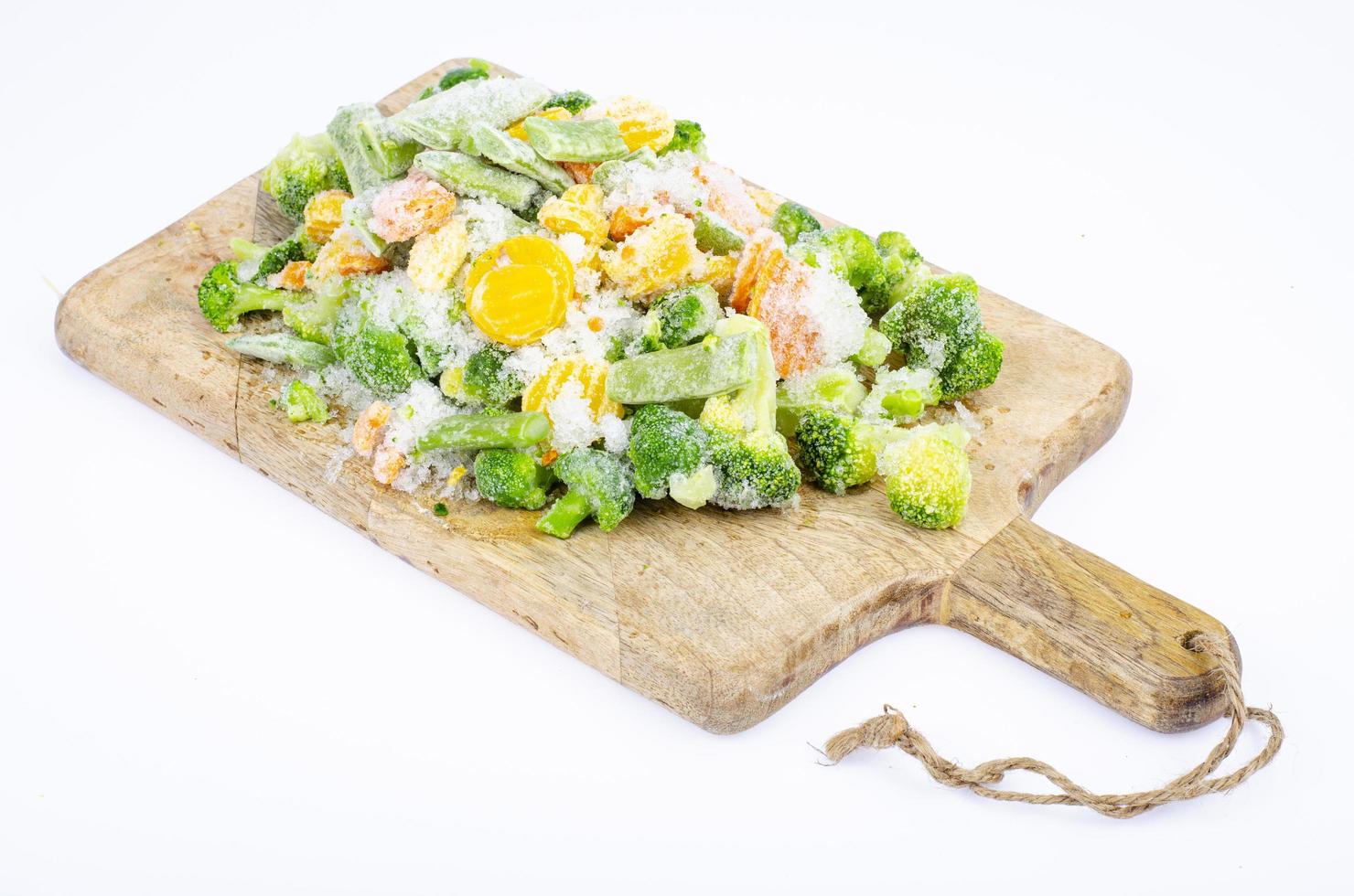 Raw frozen bio vegetables on wooden cutting board. Studio Photo. photo