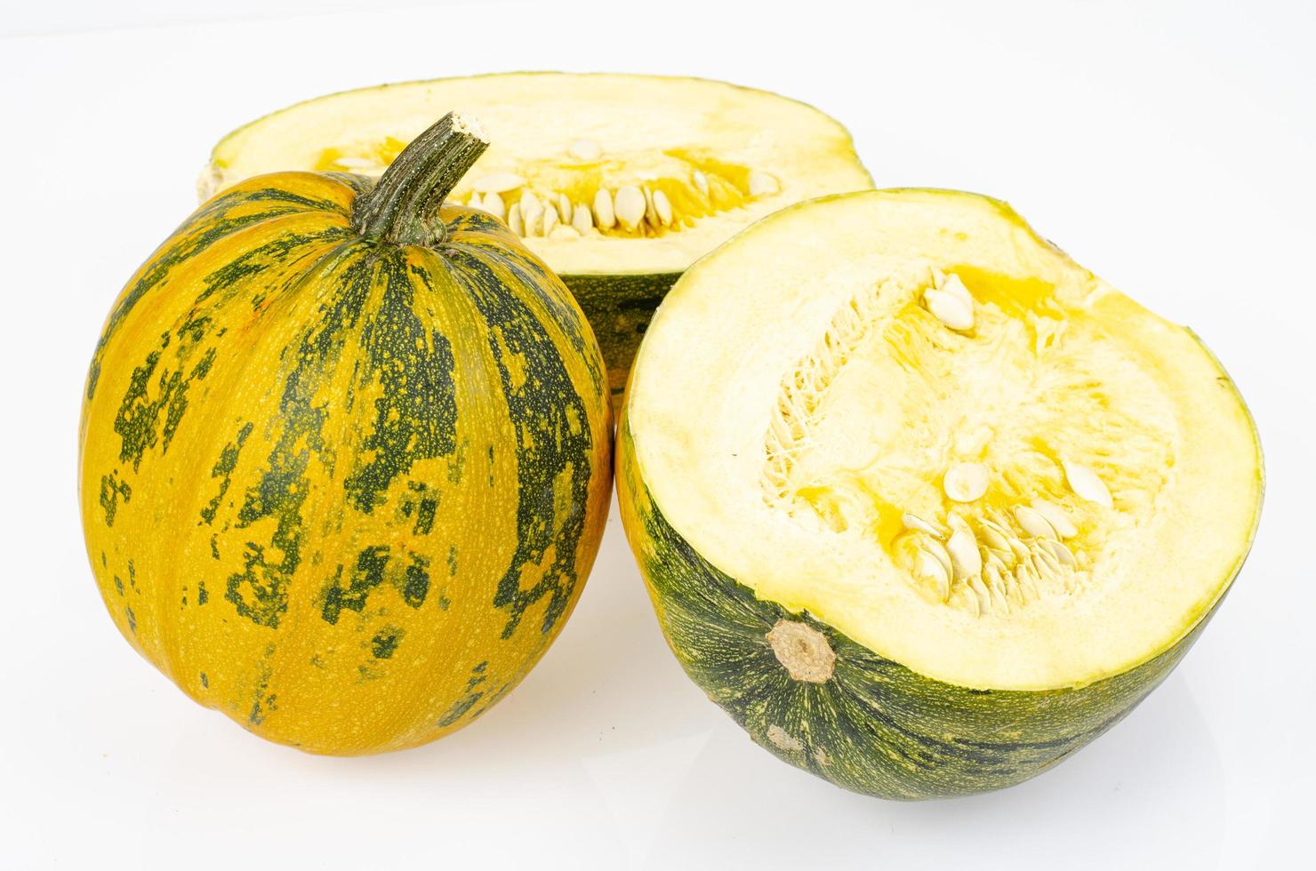 Calabaza redonda pequeña cortada por la mitad sobre fondo blanco. foto de estudio.