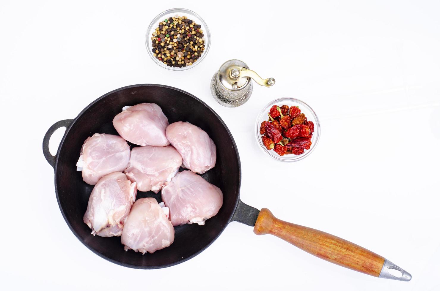 trozos crudos de pierna de pollo en una sartén para cocinar. foto de estudio.