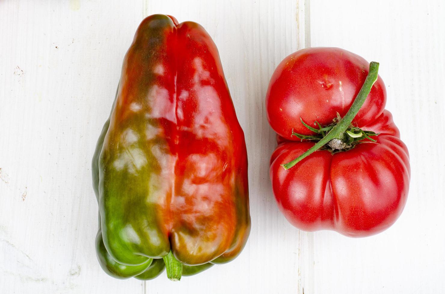 pimientos y tomates multicolores en la mesa de madera. foto de estudio.