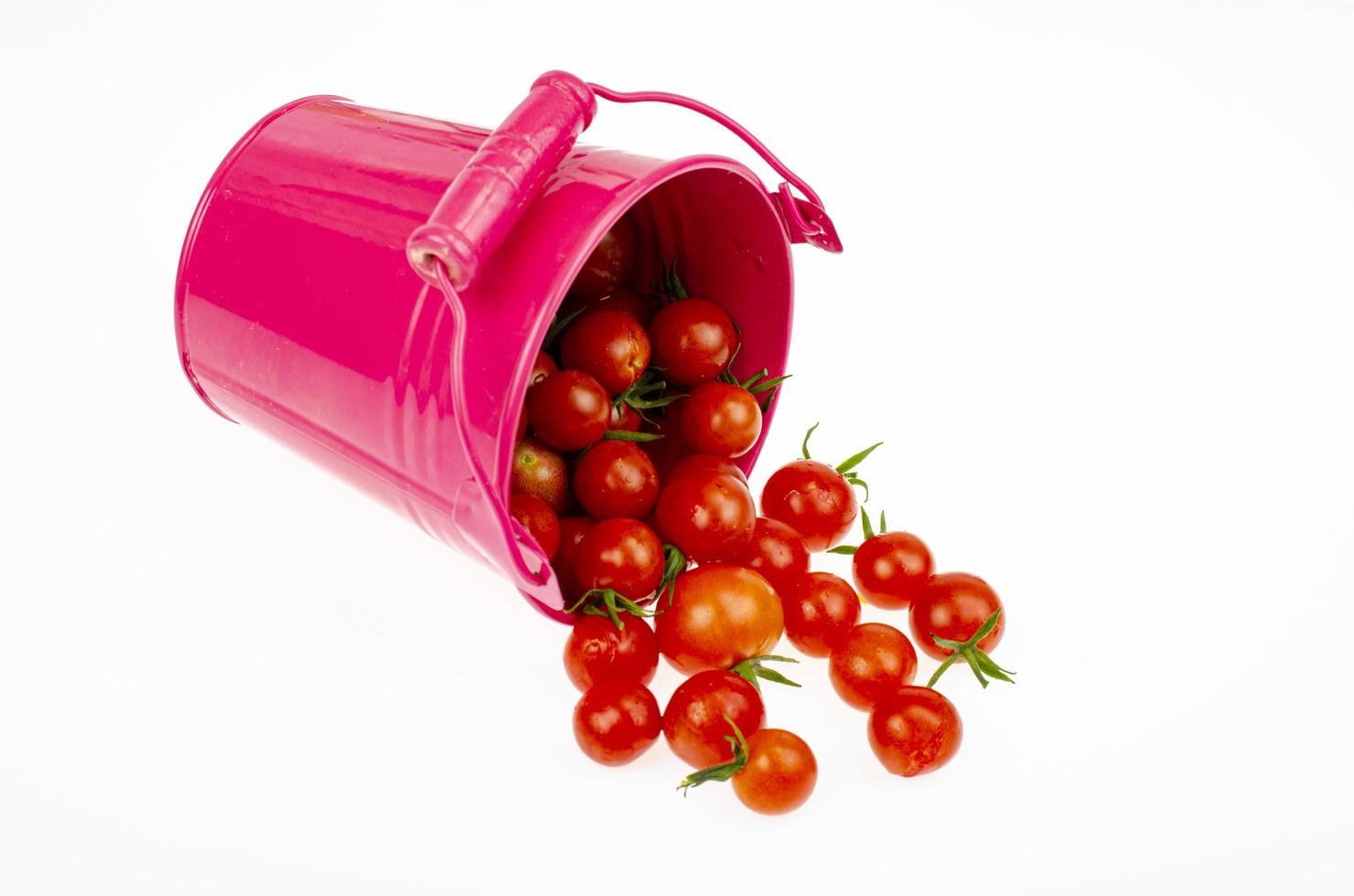 Harvesting. Red ripe tomatoes in colored buckets on white background. Studio Photo. photo