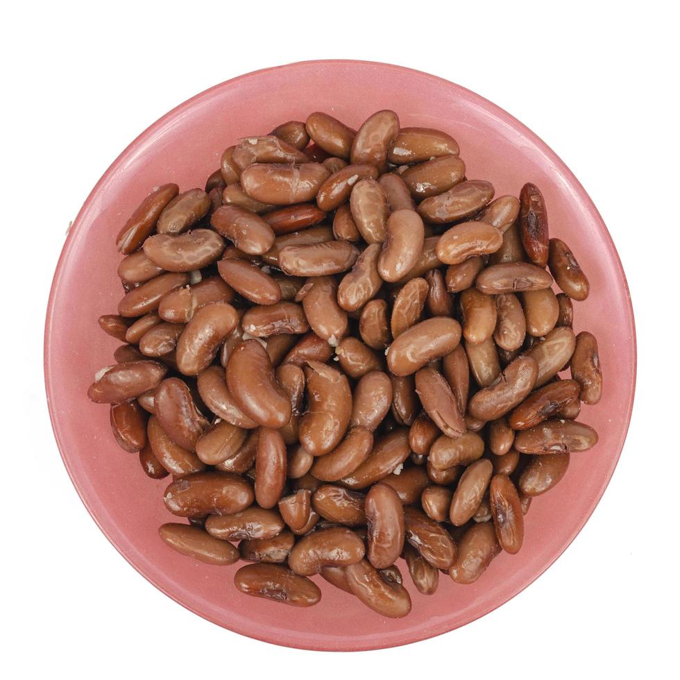 Tinned beans in red bowl on white background. Studio Photo