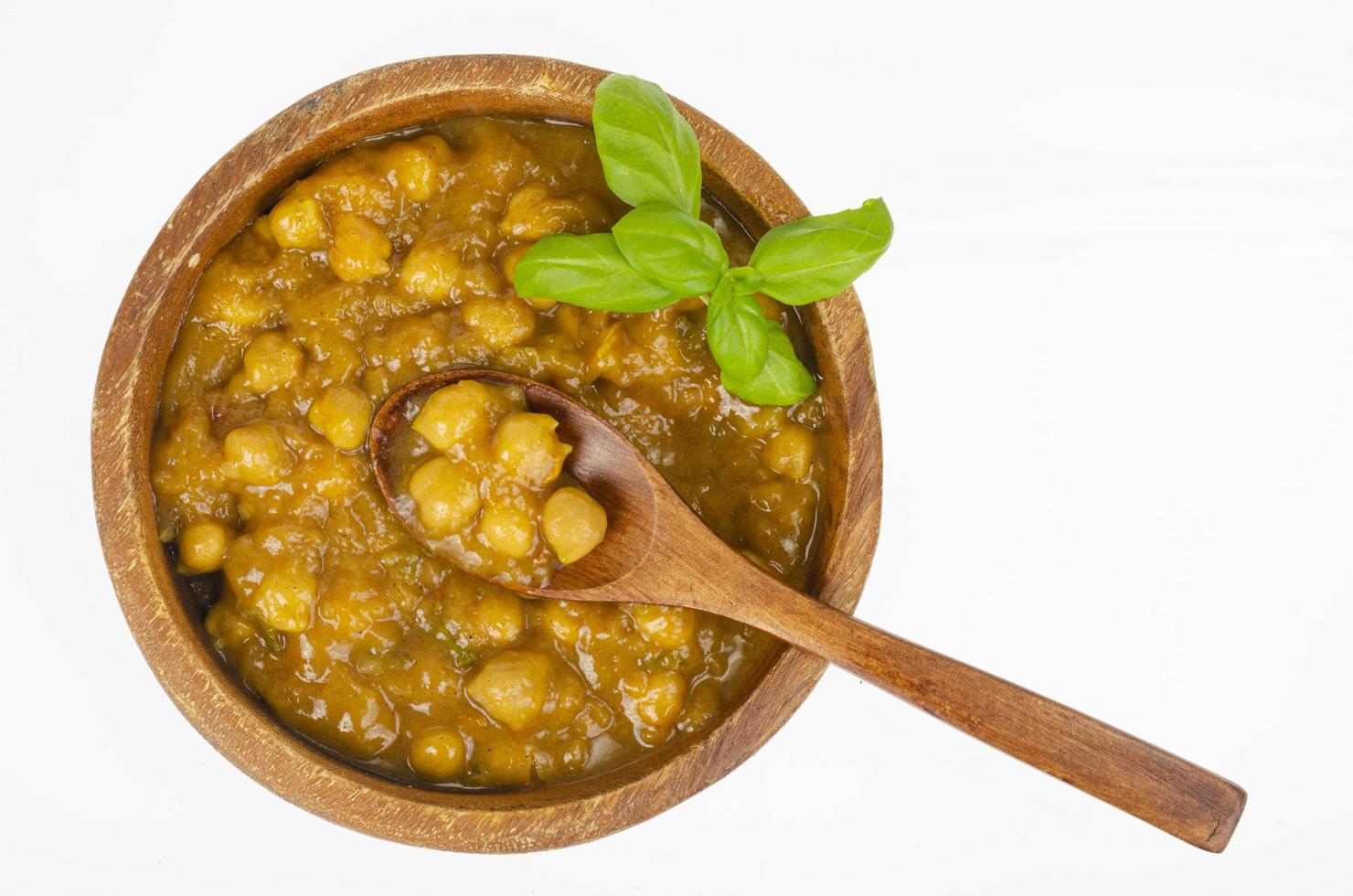 garbanzos con salsa de curry en cuenco de madera. foto de estudio