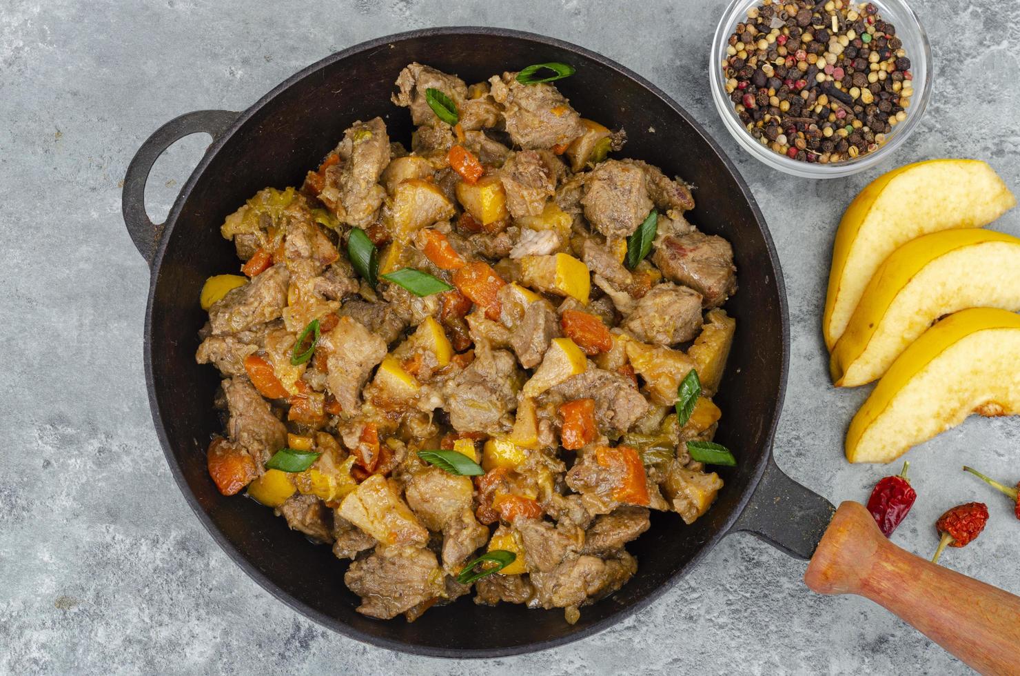 Frying pan with stew, quince and vegetables. Studio Photo