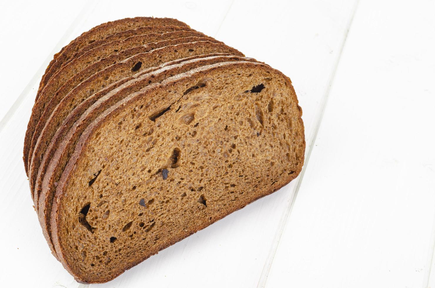 Fresh homemade pastries. Sliced rye bread on wooden background. Studio Photo