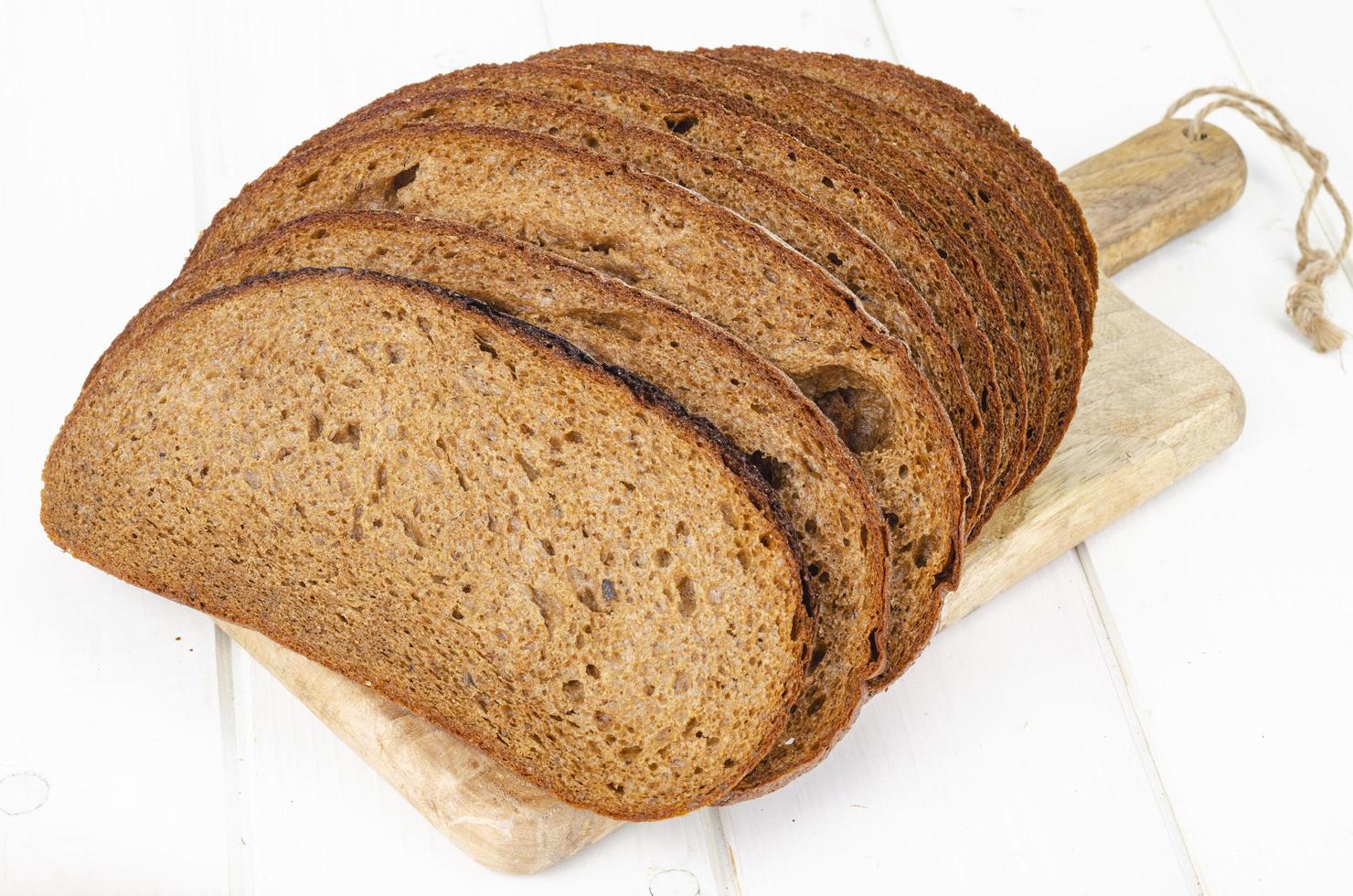 Fresh homemade pastries. Sliced rye bread on wooden background. Studio Photo